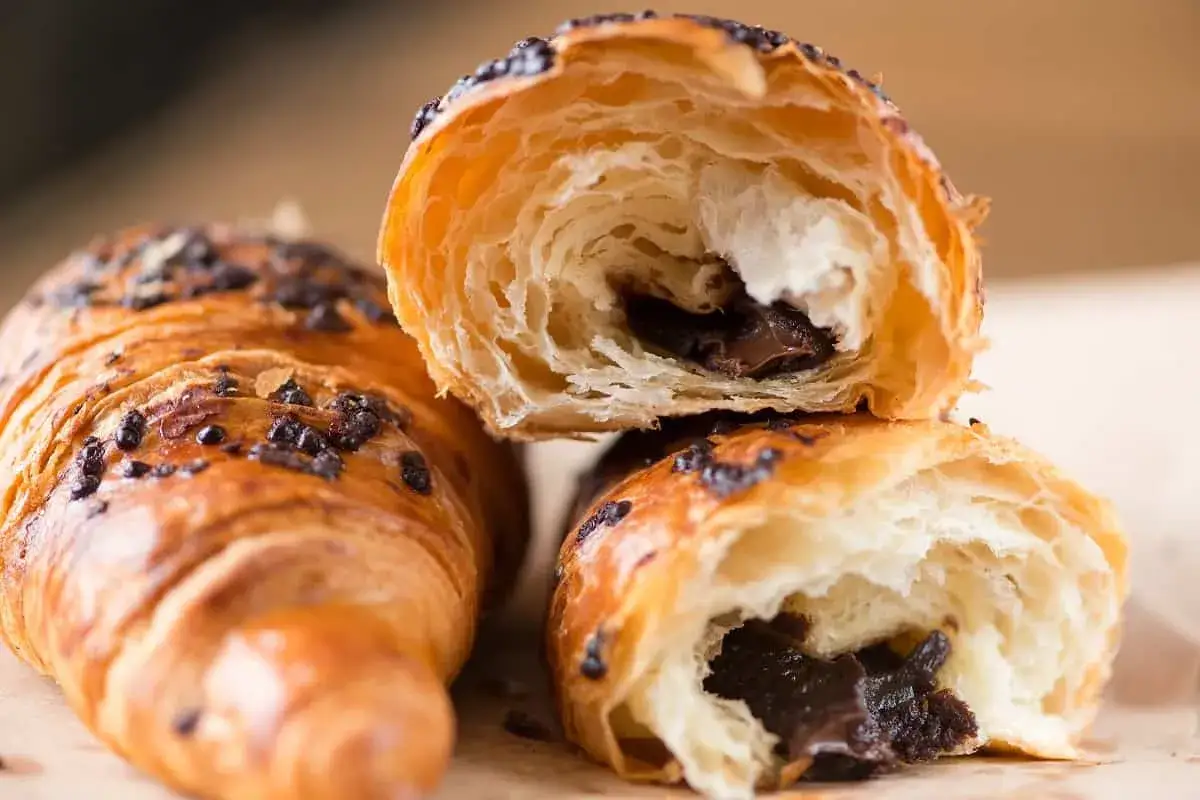 Un delicioso croissant de chocolate, con su masa hojaldrada y relleno cremoso, listo para disfrutar.