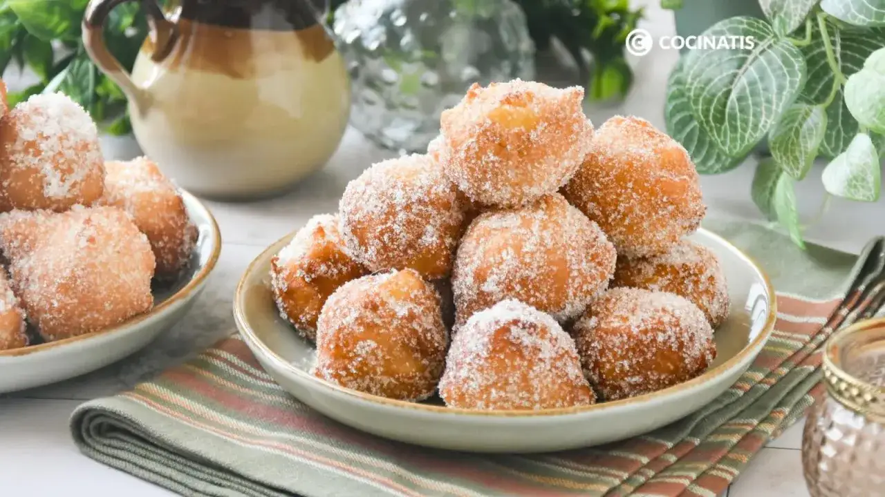 Mont&oacute;n de bu&ntilde;uelos de manzana espolvoreados con az&uacute;car, listos para disfrutar.