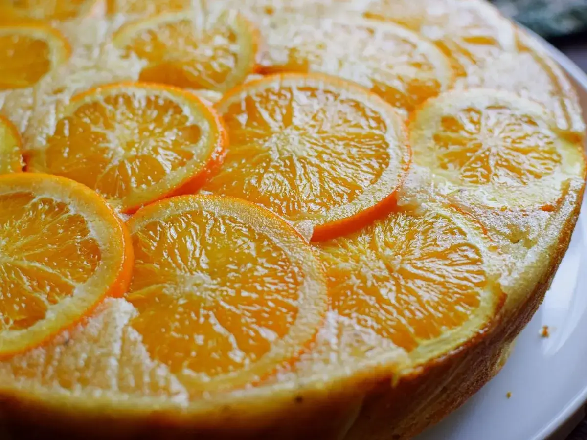 Bizcocho de naranja y yogur, decorado con rodajas de naranja fresca. Un postre casero, jugoso y arom&aacute;tico.