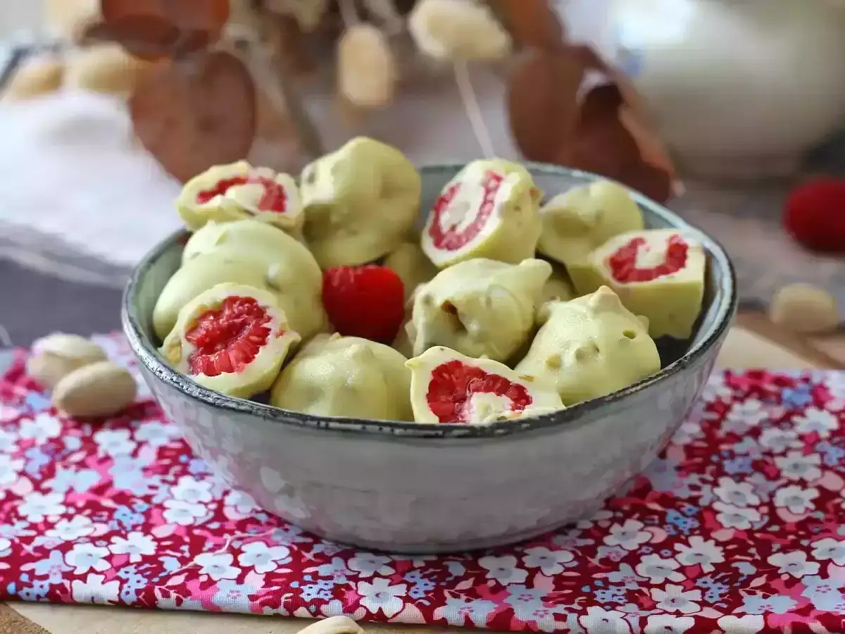 Delicioso mousse de chocolate blanco cubriendo frambuesas frescas. Un bocado dulce y refrescante.