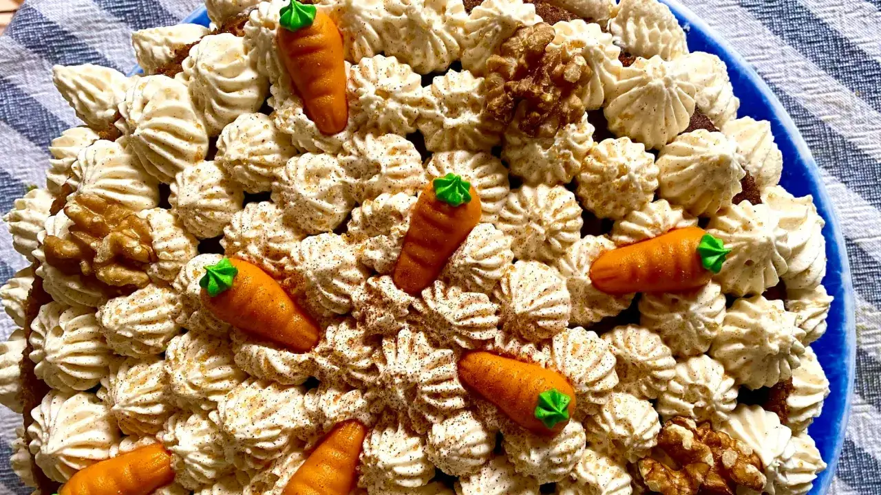Deliciosa tarta de zanahoria y coco, decorada con zanahorias de mazap&aacute;n, nueces y crema batida.