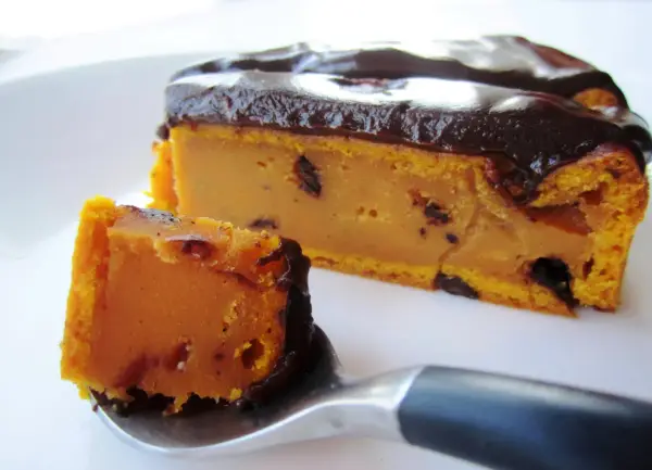 Deliciosa tarta de calabaza y chocolate, con un trozo en una cuchara listo para ser degustado.