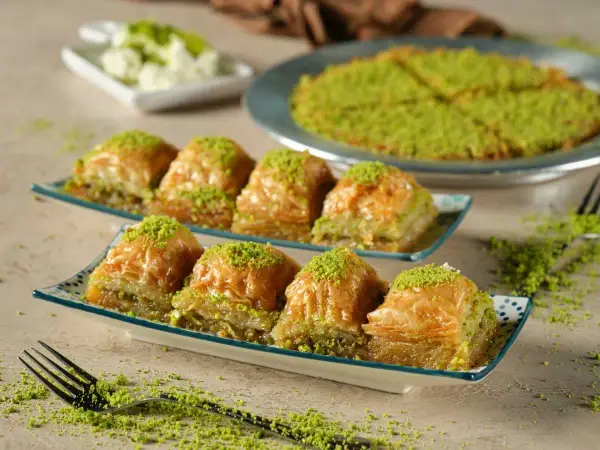 Delicioso baklava, una receta tradicional con capas crujientes y relleno de pistacho, espolvoreado con más pistacho verde.