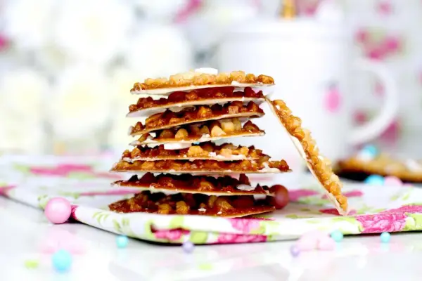Deliciosas moscovitas receta, crujientes y doradas, apiladas sobre un mantel floral.