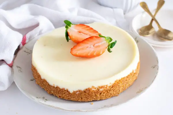 Tarta de cuajada cremosa con base crujiente y fresas frescas. Un postre delicioso y elegante.